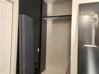Dallas – garage cabinets Photo 4 Modern alcove storage unit with black slatwall and white shelving under construction