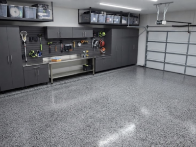 Organized garage featuring custom cabinets, overhead storage racks, and polyaspartic flooring, showcasing a transformation